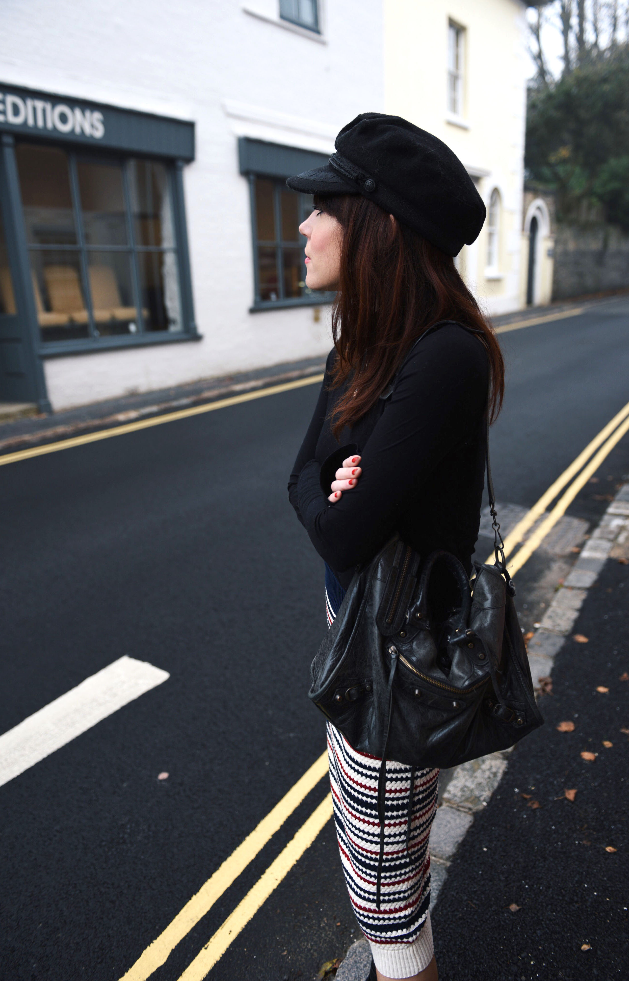 all black outfit with stripe skirt and baker boy hat